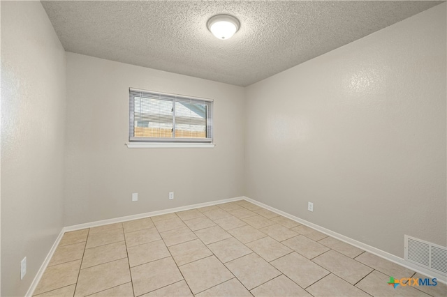 unfurnished room featuring visible vents, a textured ceiling, and baseboards