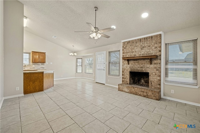 unfurnished living room featuring a fireplace, light tile patterned floors, vaulted ceiling, a textured ceiling, and ceiling fan with notable chandelier