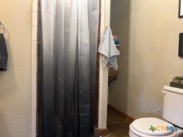 bathroom with hardwood / wood-style floors and toilet