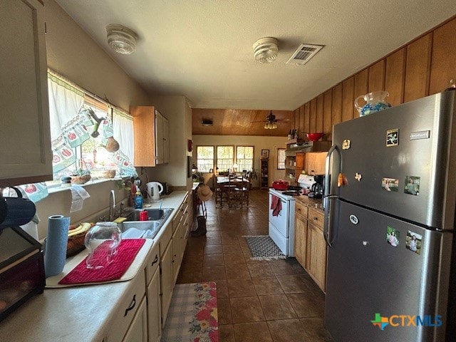 kitchen featuring stainless steel fridge, dark tile patterned floors, white range, sink, and ceiling fan