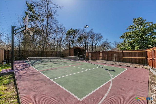 exterior space with a tennis court, community basketball court, and fence