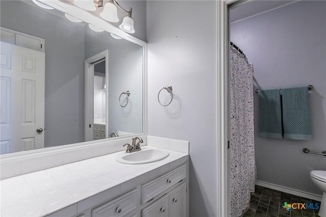 bathroom with baseboards, toilet, and vanity