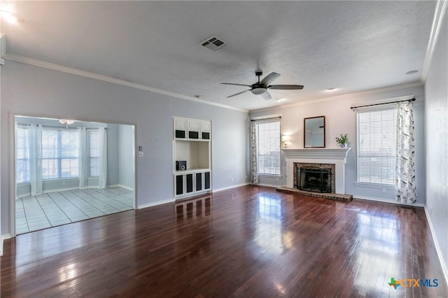 unfurnished living room with wood finished floors, a fireplace, visible vents, and a wealth of natural light