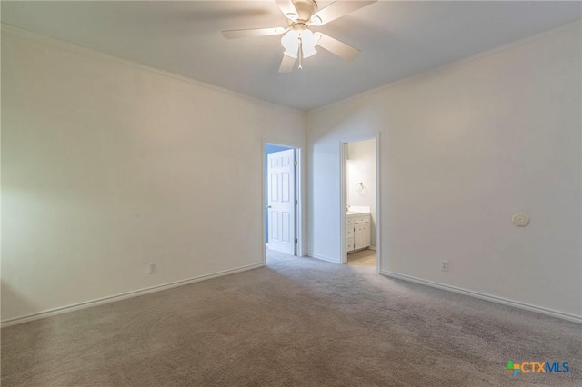 unfurnished bedroom with connected bathroom, light colored carpet, baseboards, and ornamental molding