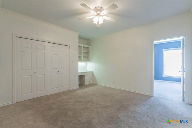 unfurnished bedroom with a closet, light carpet, baseboards, and ornamental molding