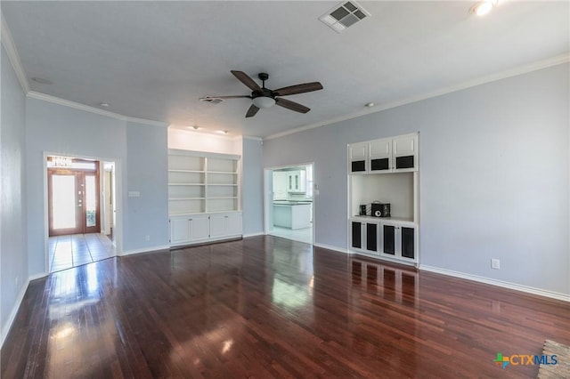 unfurnished living room featuring built in shelves, baseboards, wood finished floors, and crown molding