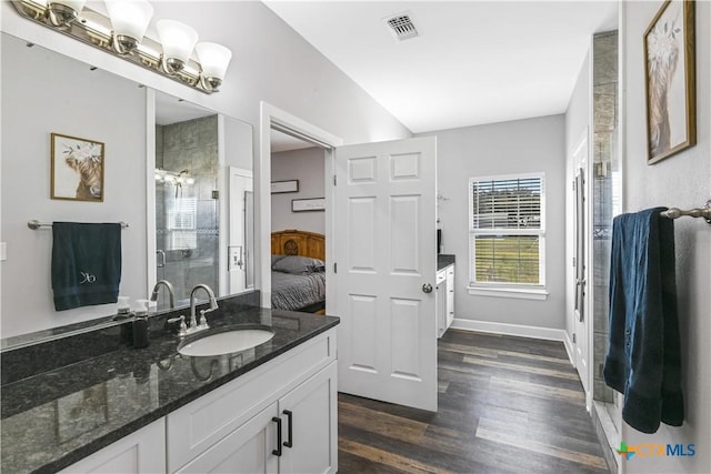 full bathroom featuring vanity, wood finished floors, visible vents, a shower stall, and connected bathroom