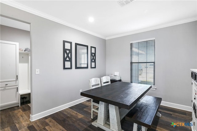 dining room featuring dark wood-type flooring, baseboards, visible vents, and ornamental molding