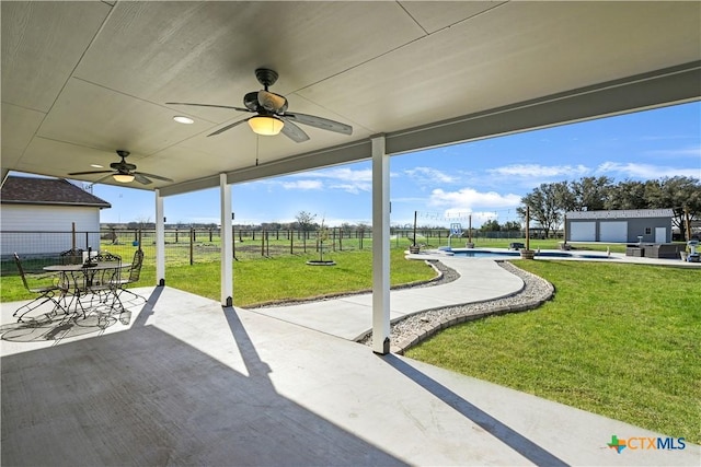 view of patio featuring ceiling fan, a fenced backyard, and a fenced in pool