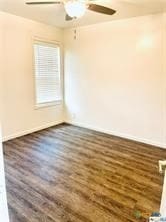 empty room with ceiling fan and dark hardwood / wood-style flooring