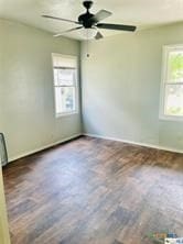 unfurnished room featuring dark hardwood / wood-style floors and ceiling fan