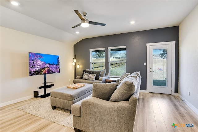 living room featuring ceiling fan, light hardwood / wood-style floors, and vaulted ceiling