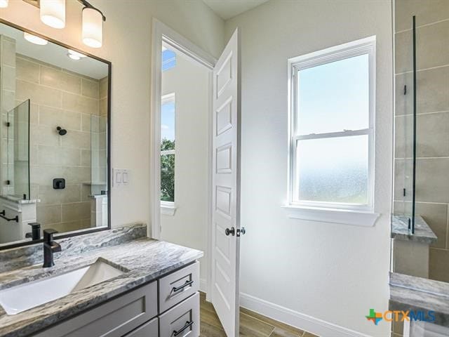 bathroom featuring hardwood / wood-style floors, vanity, and a shower with door