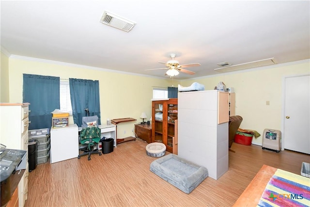 interior space with ornamental molding, ceiling fan, and light wood-type flooring