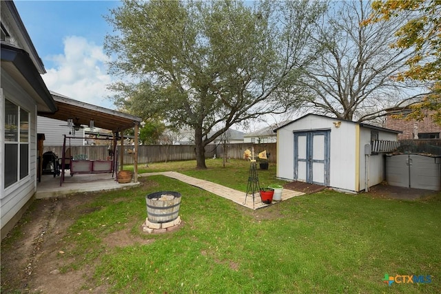 view of yard featuring a storage shed, a fire pit, and a patio