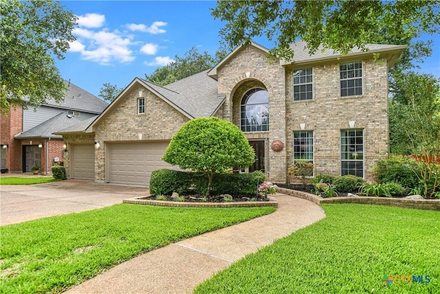 traditional-style house featuring a garage, a front yard, concrete driveway, and brick siding