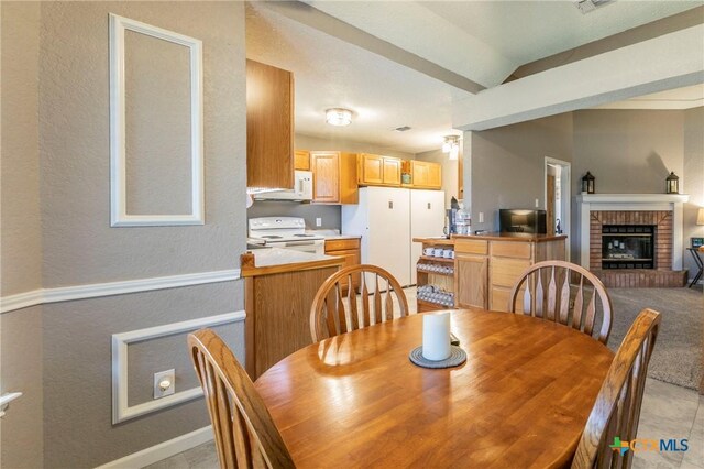 204 Paula St, Copperas Cove, TX 76522 - dining room with a brick fireplace, baseboards, lofted ceiling, and a textured wall