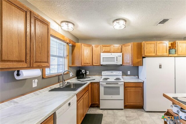 204 Paula St, Copperas Cove, TX 76522 - kitchen with visible vents, light countertops, brown cabinets, white appliances, and a sink