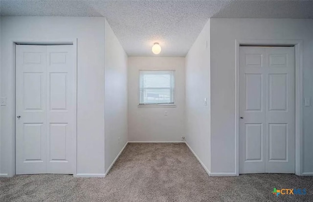 unfurnished bedroom featuring baseboards, carpet floors, and a textured ceiling