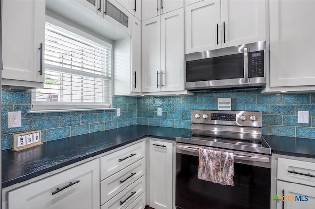 kitchen with dark countertops, stainless steel appliances, and white cabinets