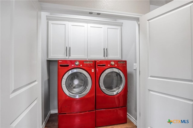 washroom with separate washer and dryer, cabinet space, and wood finished floors