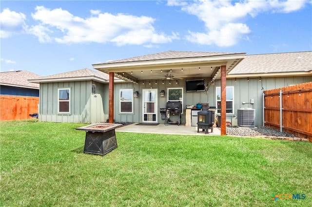 back of house with a patio area, a fire pit, a fenced backyard, a ceiling fan, and board and batten siding