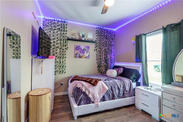 bedroom featuring baseboards, ceiling fan, and wood finished floors