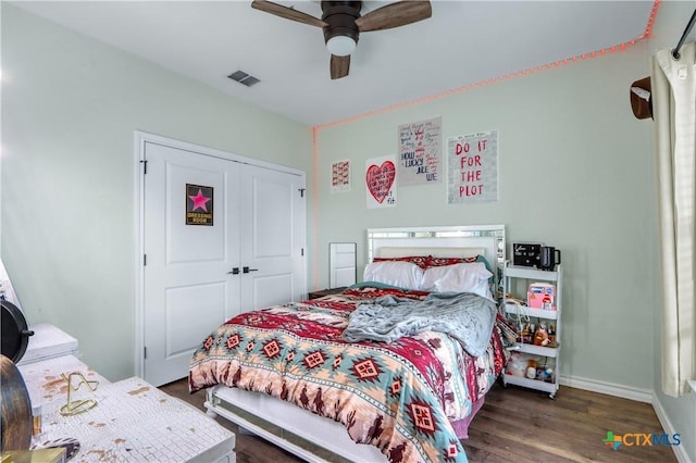 bedroom featuring a closet, wood finished floors, visible vents, ceiling fan, and baseboards