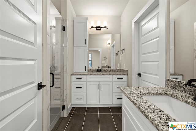 bathroom featuring tile patterned flooring, vanity, and walk in shower