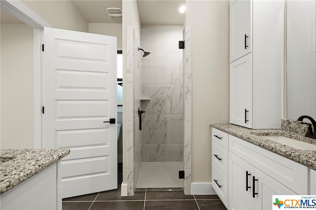 bathroom featuring tile patterned flooring, vanity, and a shower with shower door