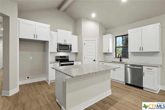 kitchen with a center island, light wood-type flooring, white cabinetry, and appliances with stainless steel finishes