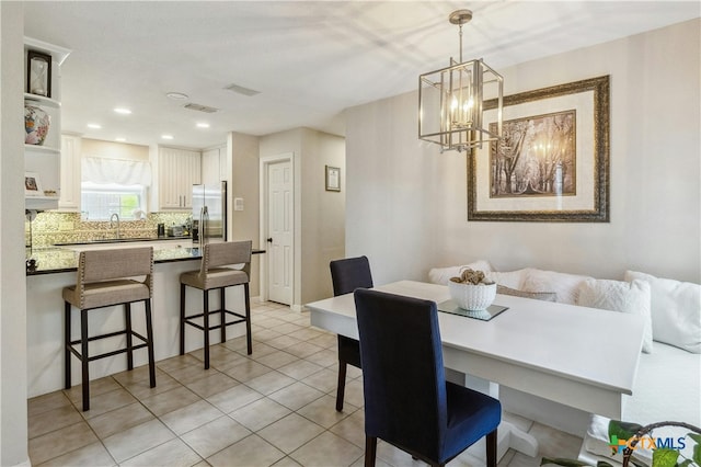 tiled dining room featuring sink