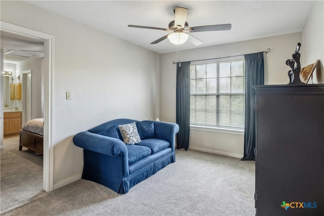 living area featuring light colored carpet and ceiling fan