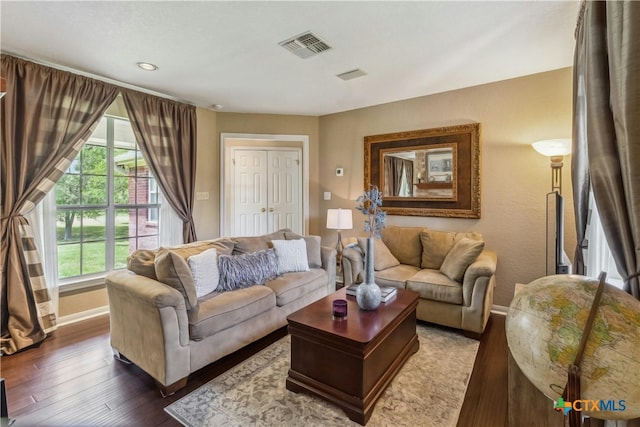 living room featuring a wealth of natural light and dark hardwood / wood-style floors