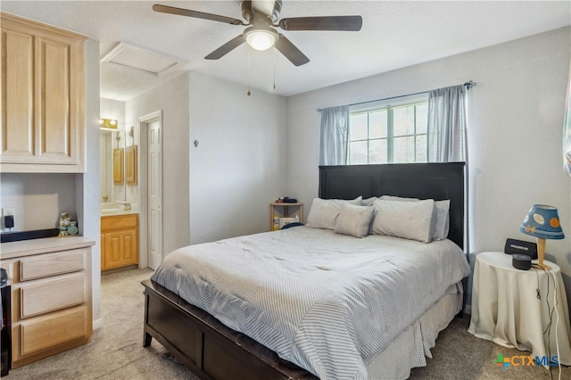 bedroom with connected bathroom, light carpet, and ceiling fan