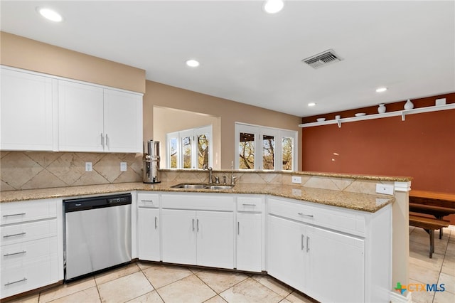 kitchen with visible vents, backsplash, a peninsula, stainless steel dishwasher, and a sink