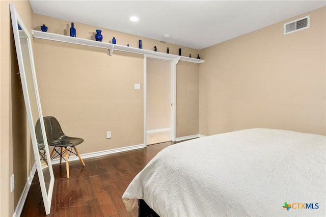 bedroom with recessed lighting, visible vents, baseboards, and wood finished floors