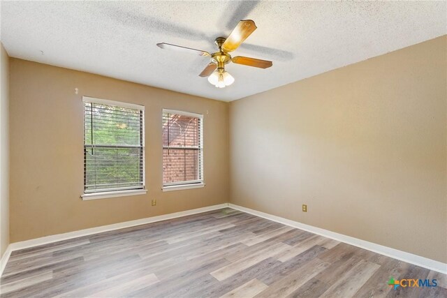 821 Old Ranch Road 12, San Marcos, TX 78666 - spare room featuring a textured ceiling, wood finished floors, a ceiling fan, and baseboards