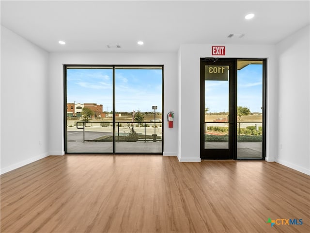 empty room featuring baseboards, wood finished floors, and recessed lighting