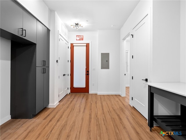 hallway with electric panel, light wood-style flooring, and baseboards