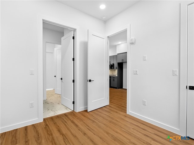 unfurnished bedroom with light wood-type flooring and baseboards