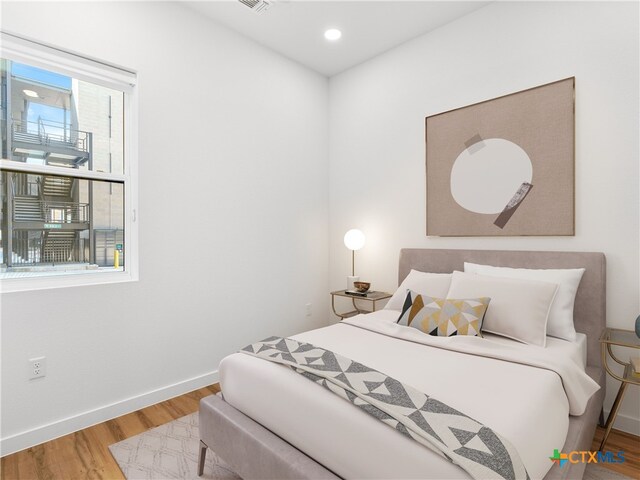 bedroom with recessed lighting, baseboards, and wood finished floors