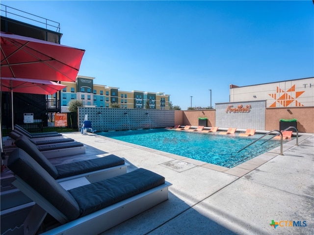 pool featuring fence and a patio