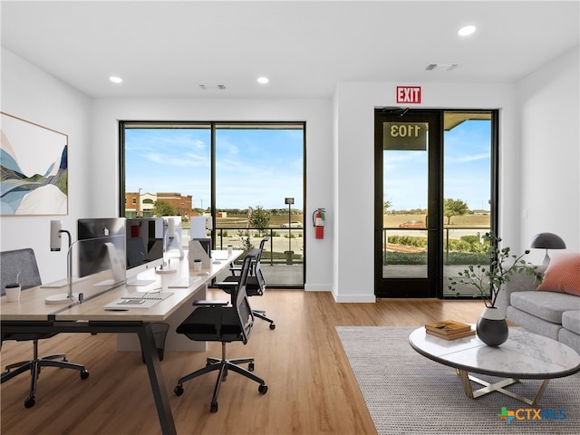 office space featuring baseboards, light wood-type flooring, and recessed lighting