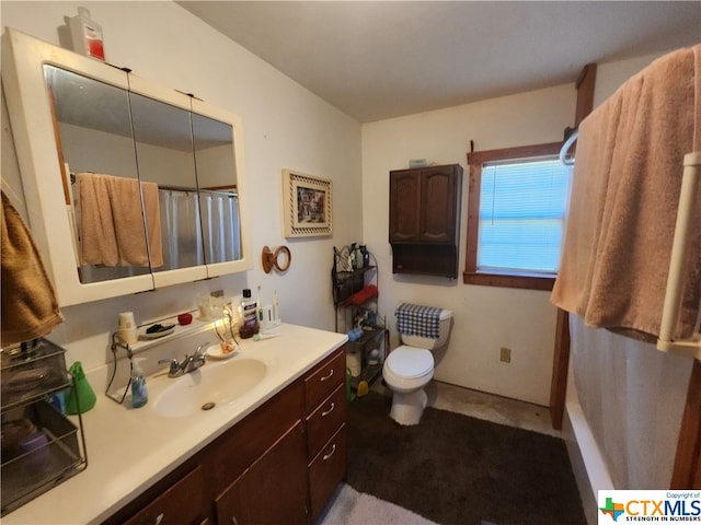 bathroom featuring walk in shower, vanity, and toilet