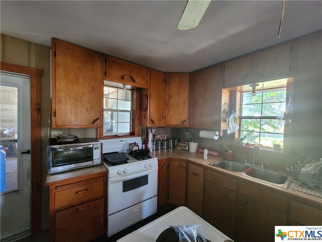 kitchen featuring white range oven and sink