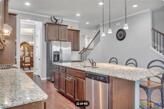 1400 Little Elm Trl Unit 1215, Cedar Park, TX 78613 - kitchen featuring appliances with stainless steel finishes, a breakfast bar area, a center island with sink, light stone counters, and crown molding