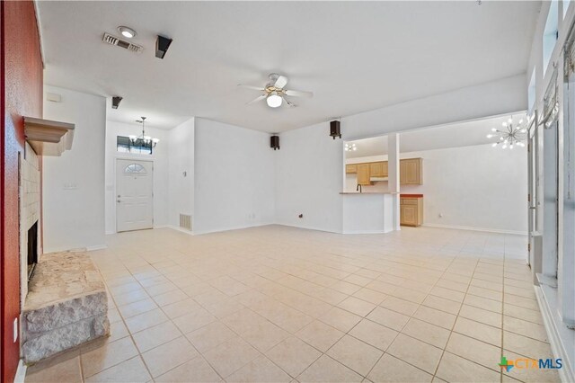 2203 Lancaster St, San Marcos, TX 78666 - unfurnished living room with a chandelier, light tile patterned flooring, a fireplace with raised hearth, and ceiling fan