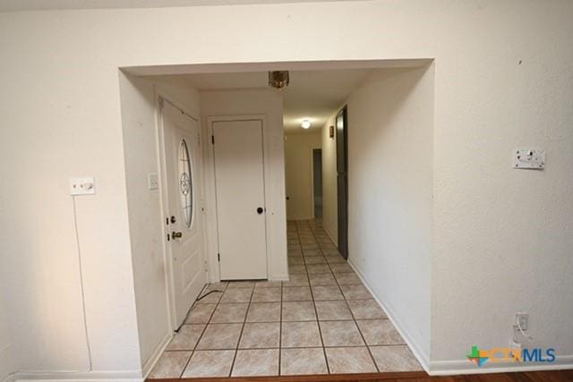 hall with light tile patterned floors