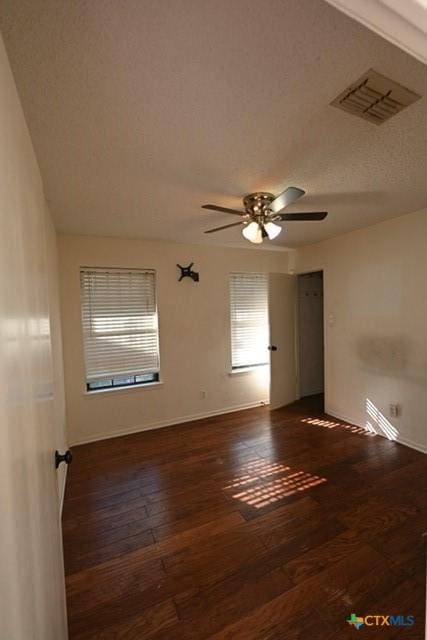 spare room with ceiling fan and dark hardwood / wood-style flooring